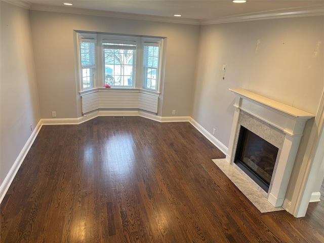 unfurnished living room with dark wood-style floors, a fireplace, baseboards, and crown molding