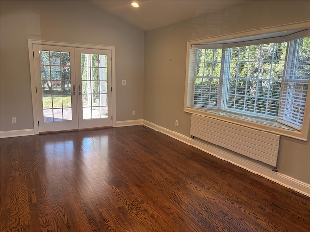 unfurnished room with dark wood-style floors, plenty of natural light, vaulted ceiling, and french doors