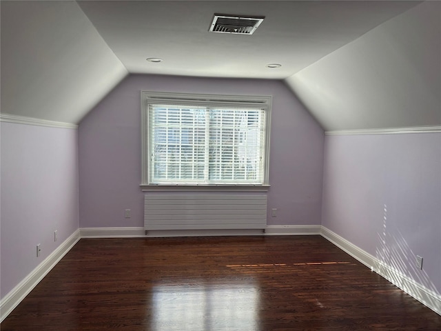 additional living space featuring vaulted ceiling, wood finished floors, visible vents, and baseboards