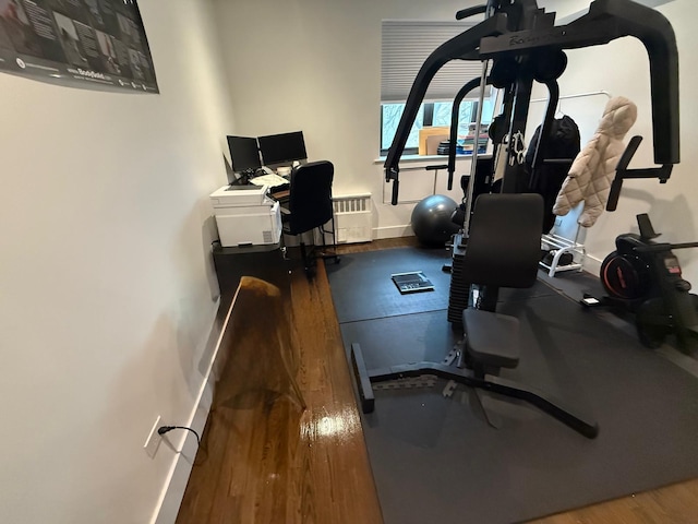 workout room with baseboards and wood finished floors