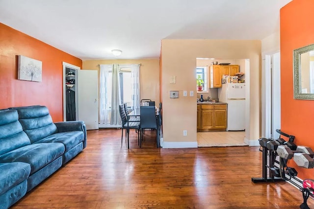 living area with plenty of natural light, baseboards, and wood finished floors