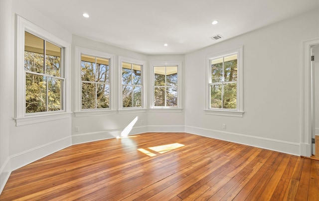 empty room with light wood-type flooring, visible vents, baseboards, and recessed lighting