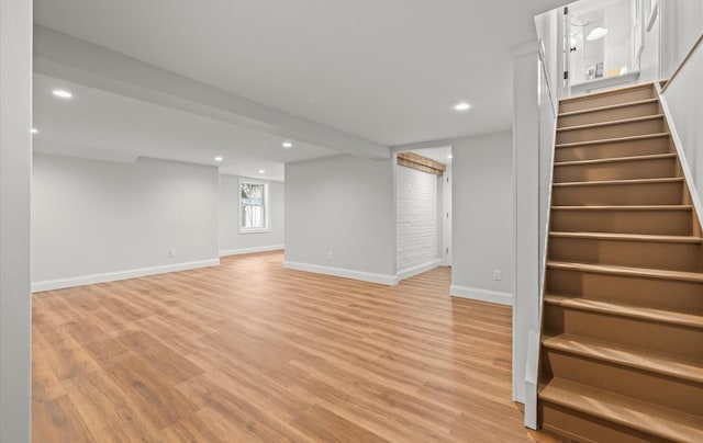 basement with light wood-style floors, recessed lighting, and stairs