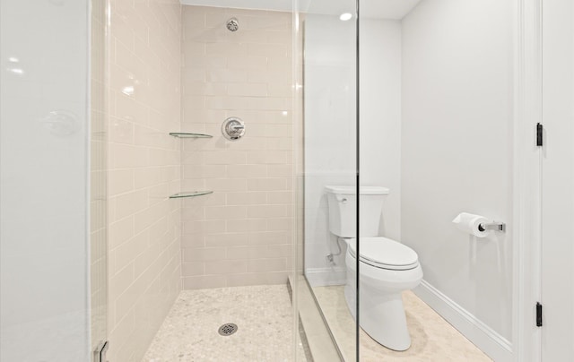 bathroom featuring baseboards, a shower stall, toilet, and tile patterned floors