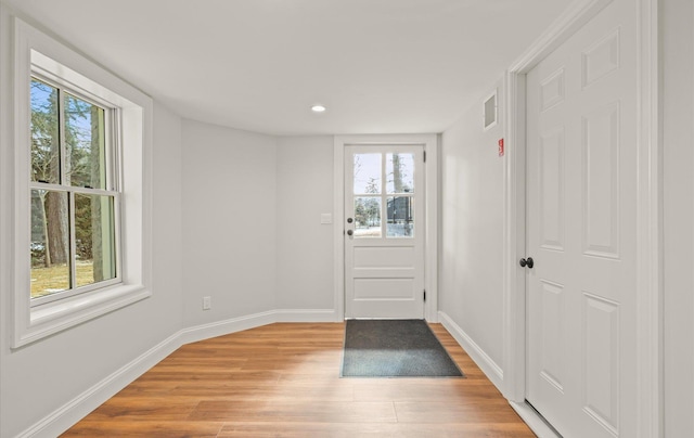 doorway to outside featuring light wood-type flooring, visible vents, baseboards, and recessed lighting