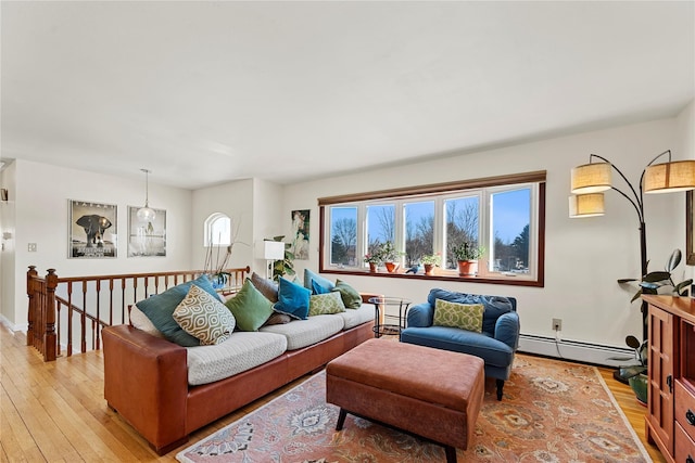 living area featuring light wood-style flooring and a baseboard heating unit