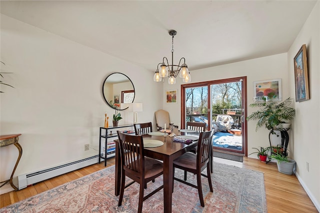 dining space with a baseboard radiator, baseboards, a notable chandelier, and light wood finished floors