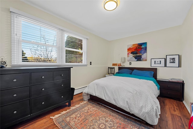 bedroom with dark wood-style floors, baseboards, and baseboard heating