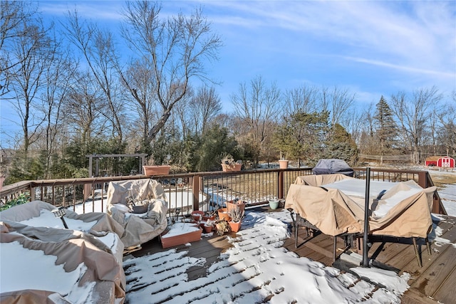 snow covered deck with a grill