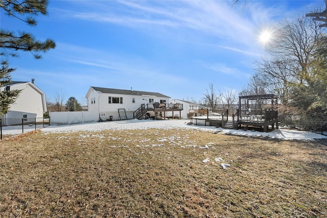 snow covered property featuring a deck, fence, and stairs