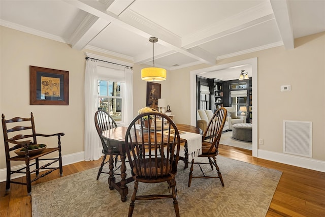 dining space with wood finished floors, visible vents, and baseboards