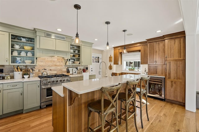 kitchen with beverage cooler, light countertops, stainless steel stove, light wood-style floors, and open shelves