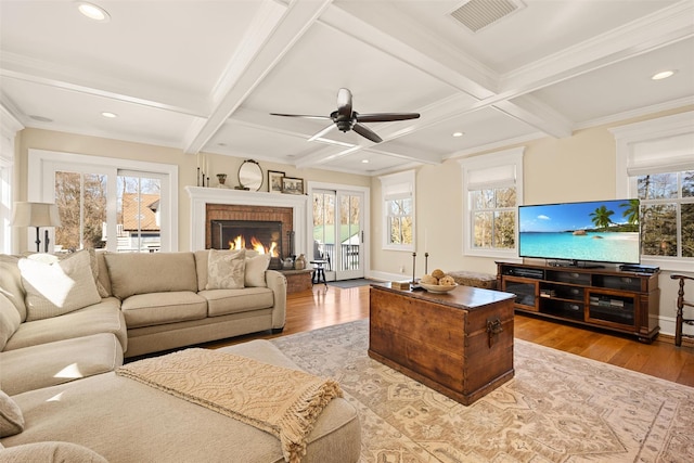 living area with a healthy amount of sunlight, visible vents, and light wood finished floors