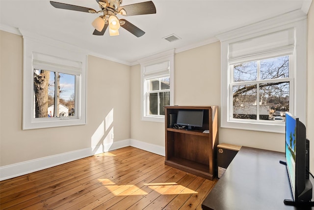 unfurnished office with crown molding, visible vents, ceiling fan, light wood-type flooring, and baseboards