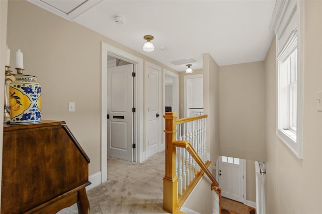 corridor featuring baseboards, light colored carpet, and an upstairs landing