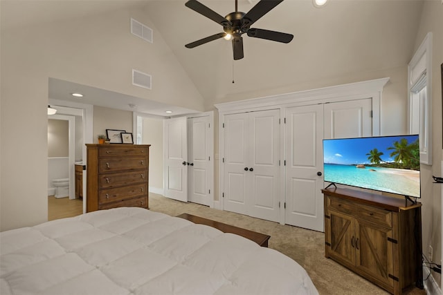 bedroom with high vaulted ceiling, light colored carpet, visible vents, and two closets