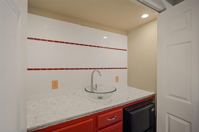 interior space featuring recessed lighting, a sink, light countertops, reddish brown cabinets, and tasteful backsplash