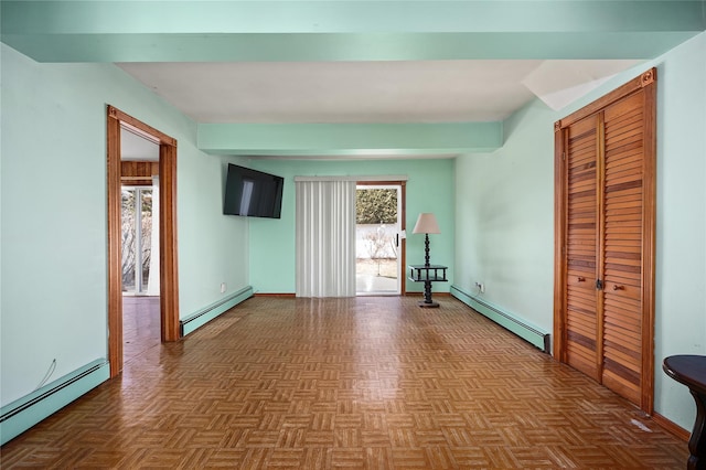 spare room featuring a healthy amount of sunlight and baseboard heating