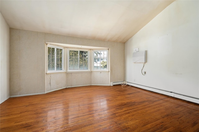 unfurnished room featuring vaulted ceiling, a baseboard radiator, wood finished floors, and a wall mounted air conditioner