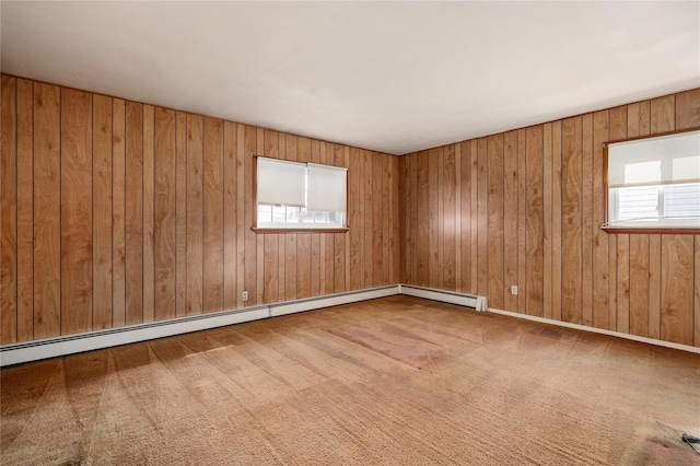 spare room with a baseboard heating unit and carpet