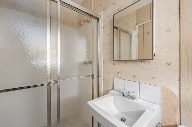 bathroom featuring a sink and a shower stall