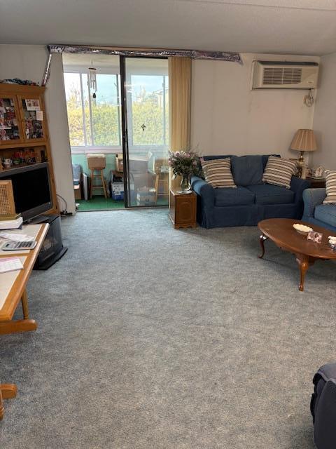 carpeted living room featuring a wall mounted air conditioner