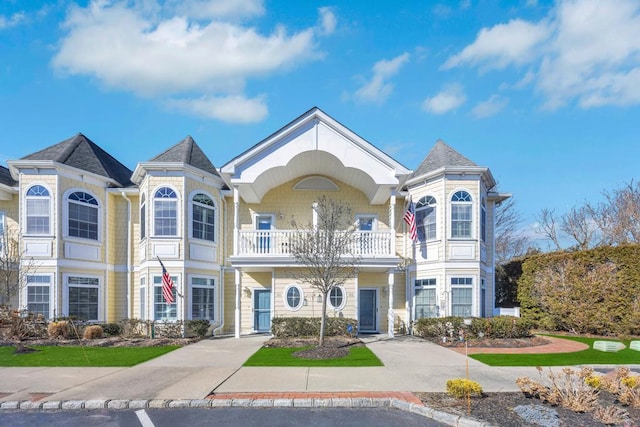 victorian-style house with concrete driveway and a balcony