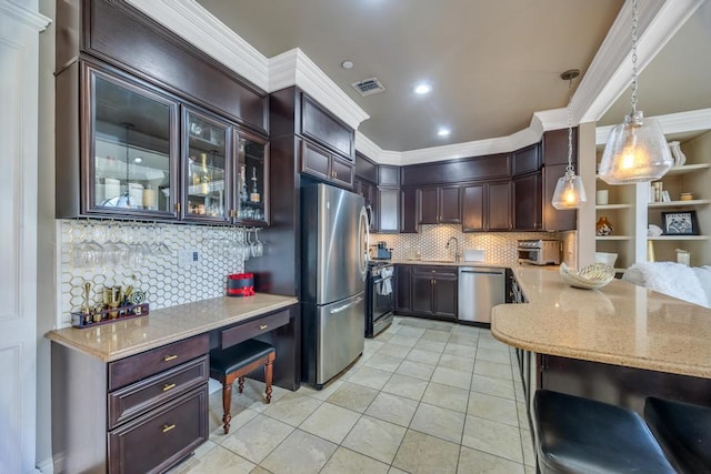 kitchen featuring visible vents, hanging light fixtures, appliances with stainless steel finishes, dark brown cabinets, and glass insert cabinets