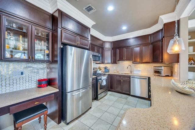 kitchen featuring visible vents, appliances with stainless steel finishes, glass insert cabinets, hanging light fixtures, and a sink