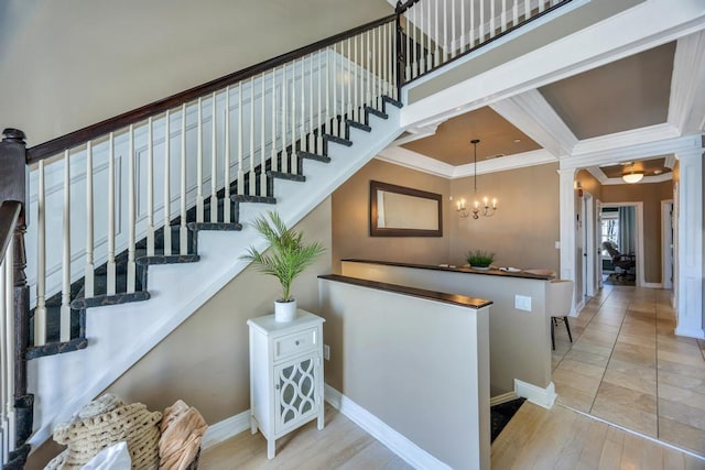 interior space with a chandelier, ornamental molding, decorative columns, and baseboards