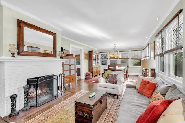 living room with baseboards, a fireplace, wood finished floors, and crown molding