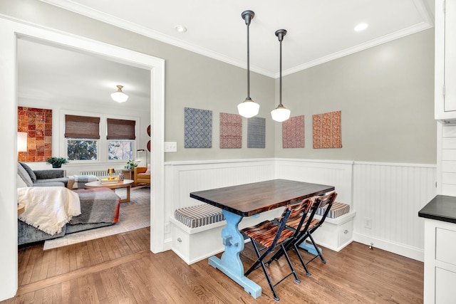 dining area with breakfast area, a wainscoted wall, and wood finished floors