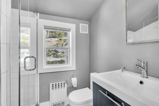 bathroom featuring visible vents, toilet, radiator heating unit, vaulted ceiling, and a sink