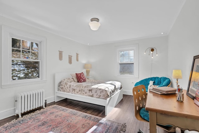 bedroom featuring radiator, baseboards, and wood finished floors