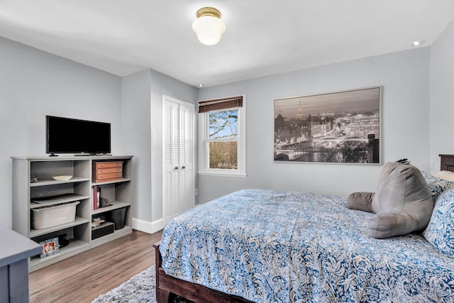 bedroom with a closet, baseboards, and wood finished floors