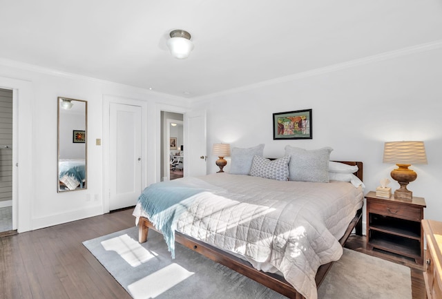 bedroom with baseboards, dark wood-type flooring, and crown molding