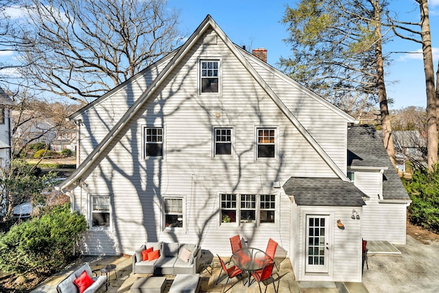 rear view of house featuring a chimney, an outdoor hangout area, and a patio