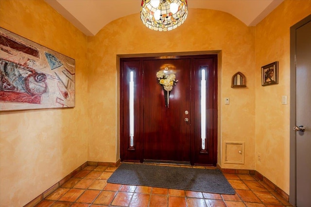 entrance foyer with vaulted ceiling and baseboards