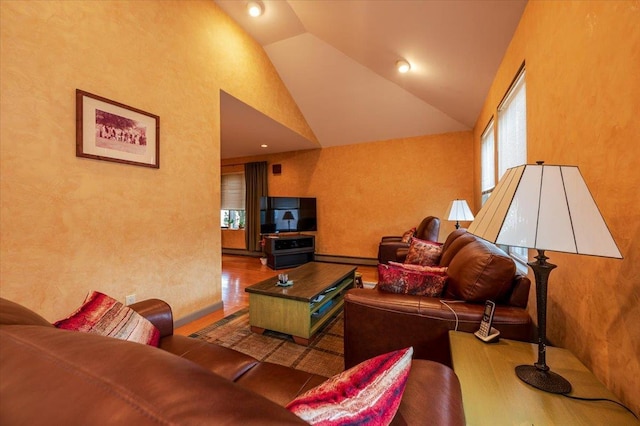 living area with high vaulted ceiling, a baseboard radiator, and wood finished floors
