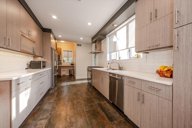 kitchen with light countertops, premium appliances, a sink, and visible vents