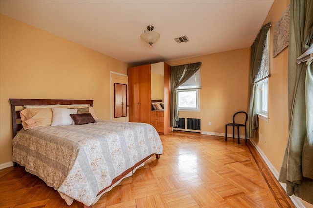 bedroom with radiator, visible vents, and baseboards