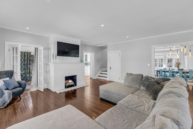 living area with crown molding, a fireplace, wood finished floors, and recessed lighting