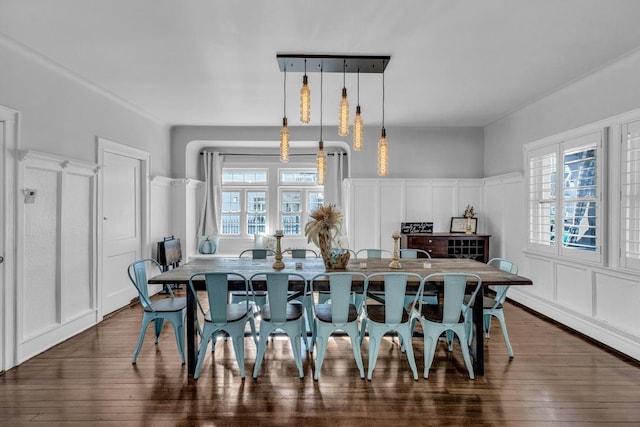 dining room with dark wood-style flooring and a decorative wall