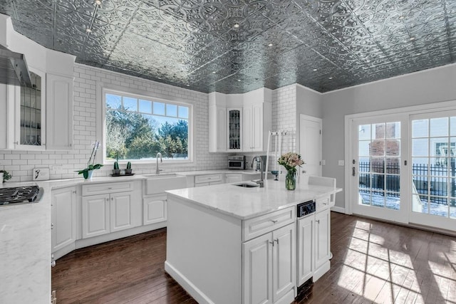 kitchen featuring dark wood-style floors, backsplash, a sink, and an ornate ceiling