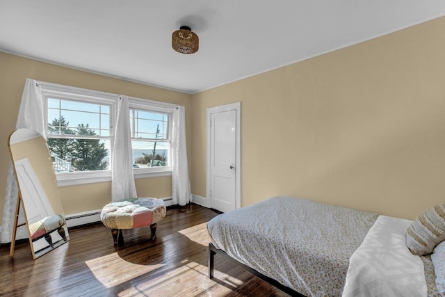 bedroom with baseboards, baseboard heating, and wood finished floors