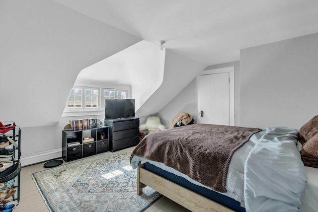 bedroom with lofted ceiling and a baseboard radiator