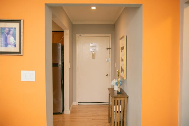 corridor with light wood-type flooring, crown molding, and recessed lighting