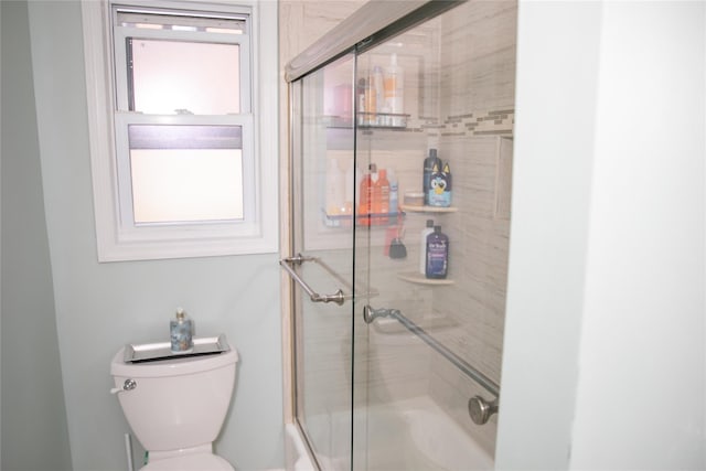 full bathroom featuring bath / shower combo with glass door and toilet