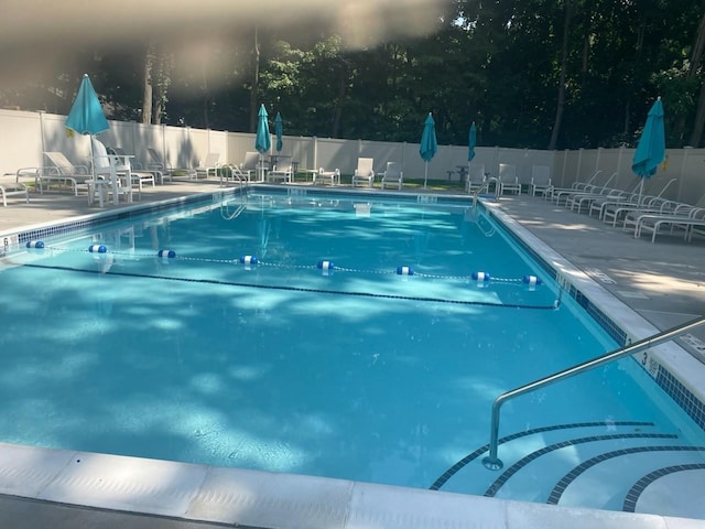 pool with a patio area and fence