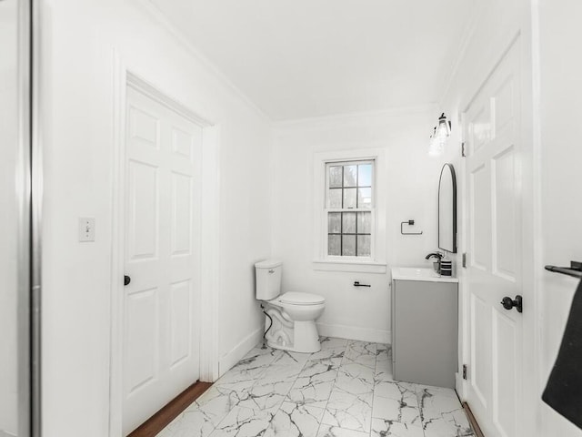 half bathroom featuring toilet, vanity, baseboards, marble finish floor, and ornamental molding